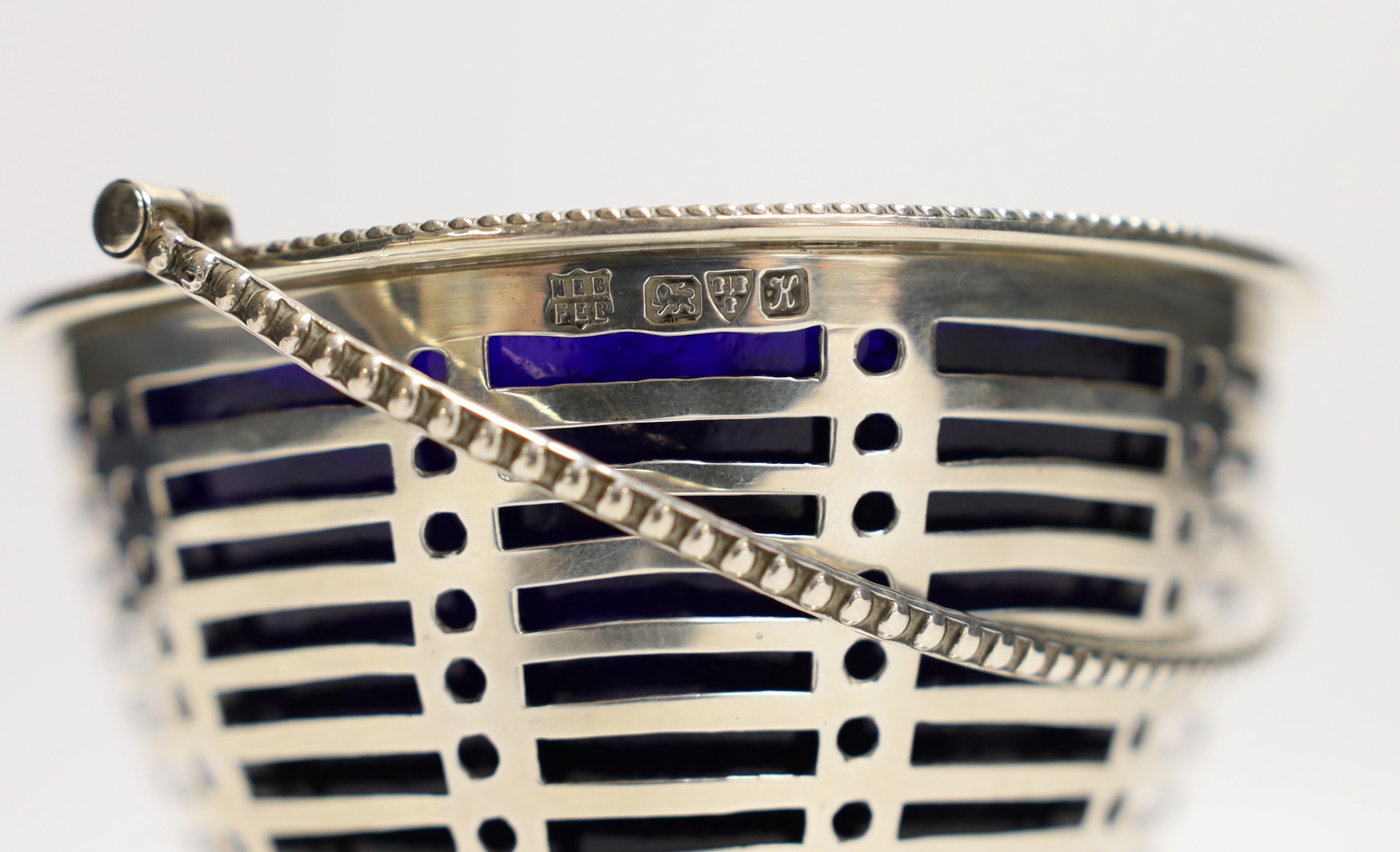 A George V pierced silver sugar vase, with blue glass liner, Barker Brothers, Chester, 1910, height 85mm.